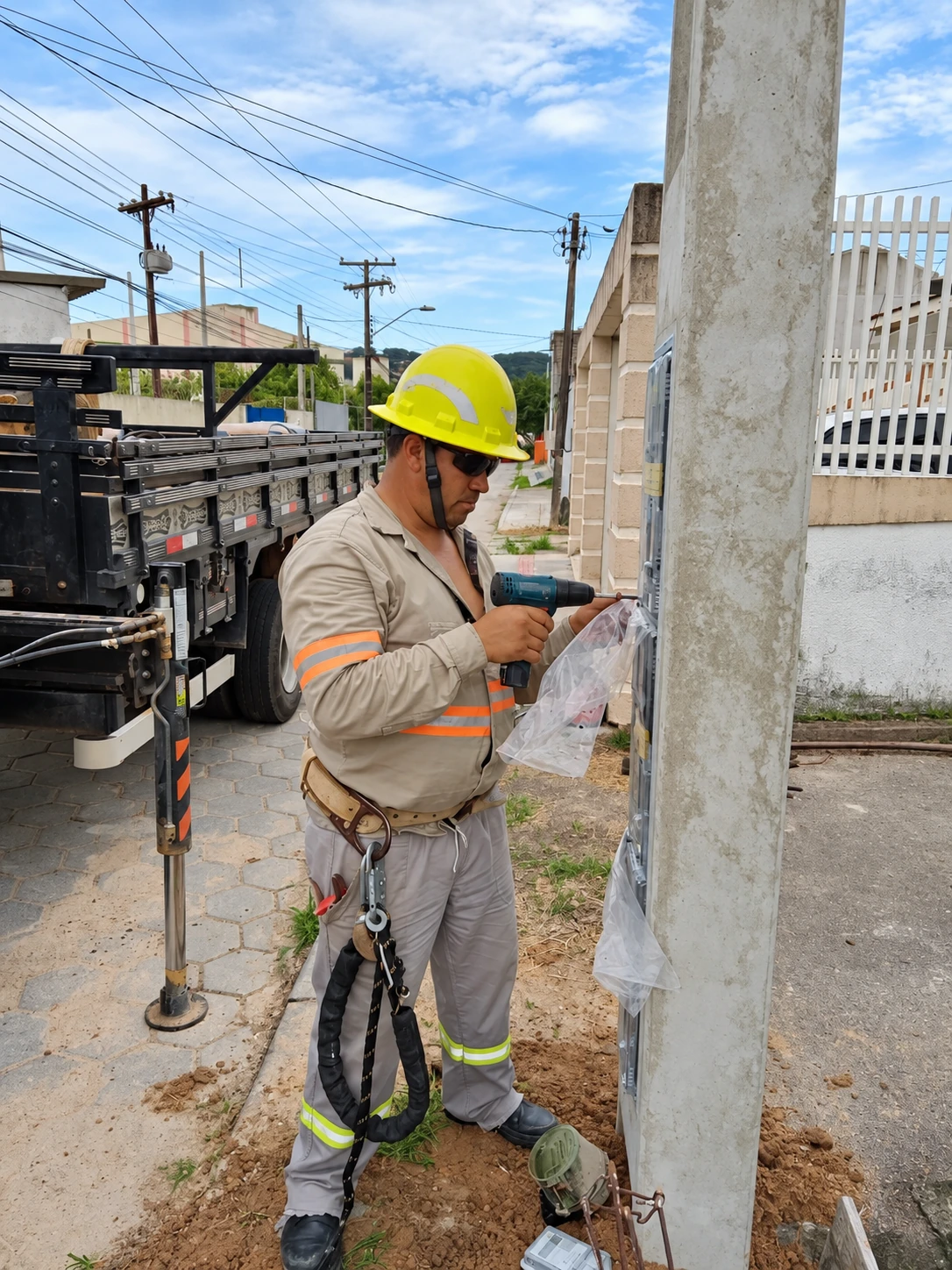 Profissional usando uma furadeira durante a montagem do padrão de entrada de energia