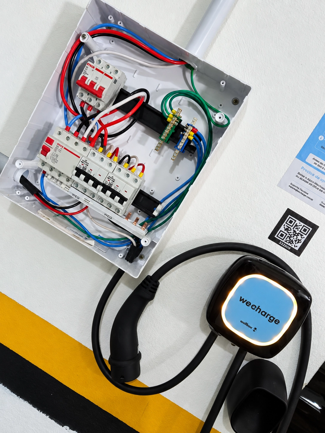 Quadro elétrico aberto junto a carregador veicular Wallbox