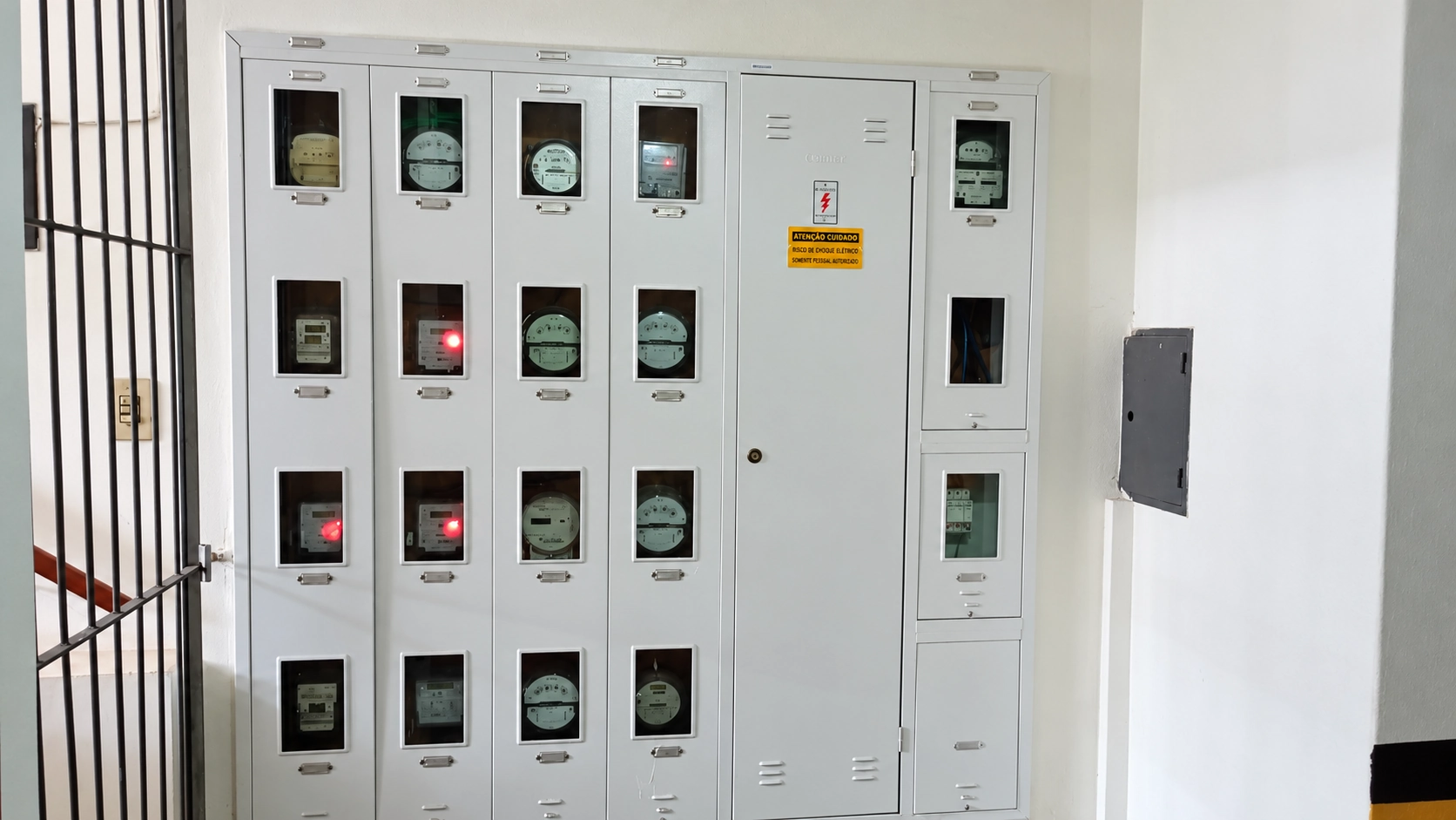 Painel com diversos medidores de energia elétrica instalado em corredor