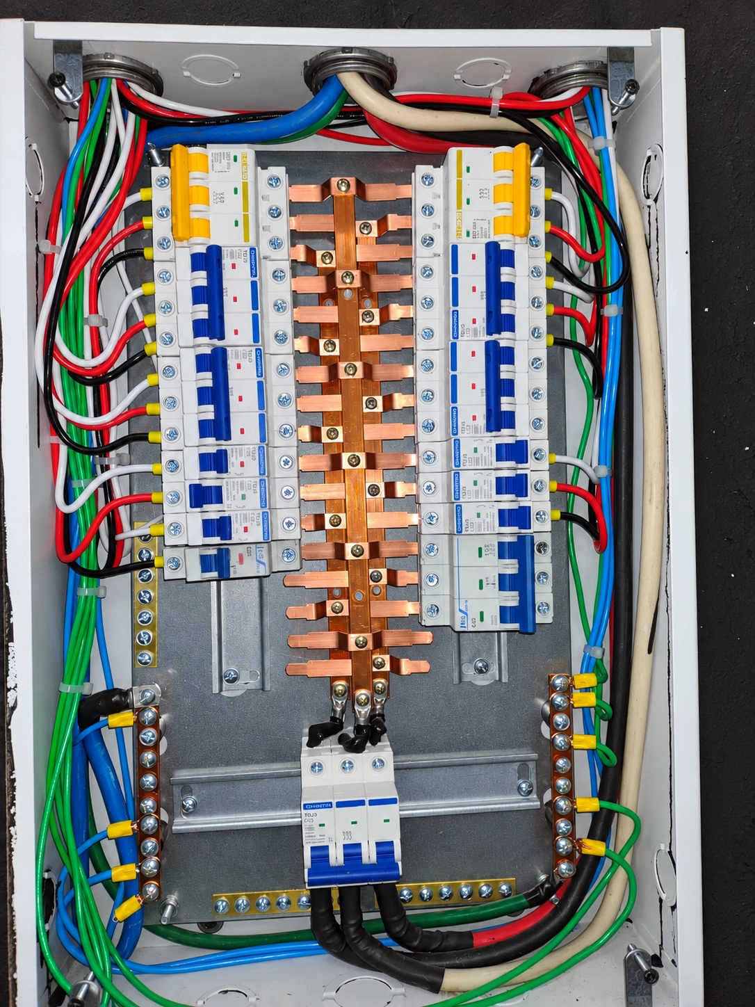 Quadro elétrico aberto com barramentos de cobre, disjuntores e fios organizados