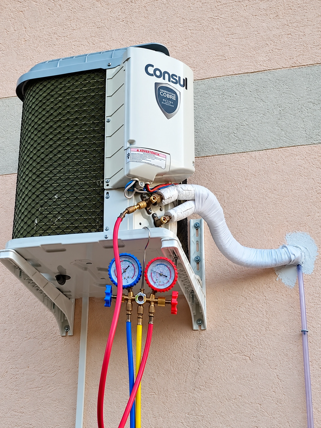 Condensadora de ar-condicionado Consul conectada a manômetros e mangueiras durante atendimento
